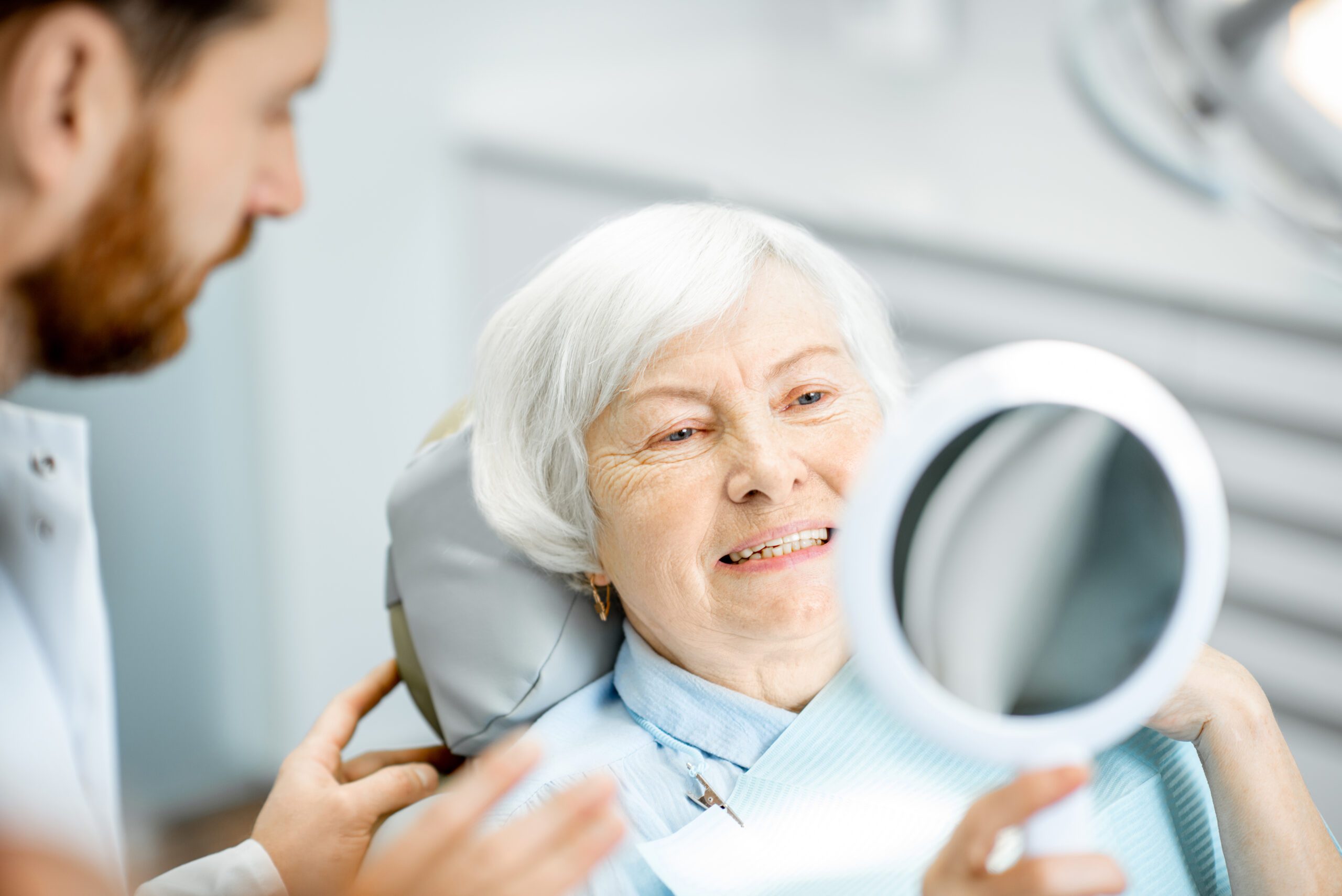 Elderly woman enjoying her smile in the dental office Portrait of a smiling doctor in front of his team